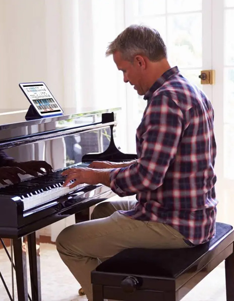 A music producer sitting at a keyboard with headphones on